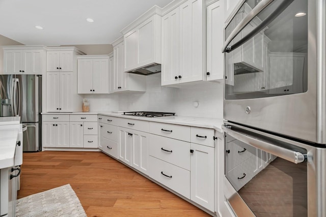 20111 N Woodland Cir, Mokena, IL 60448 - kitchen with appliances with stainless steel finishes, white cabinets, decorative backsplash, light wood-style flooring, and recessed lighting