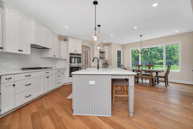 20111 N Woodland Cir, Mokena, IL 60448 - kitchen featuring stainless steel double oven, light countertops, light wood finished floors, backsplash, and recessed lighting