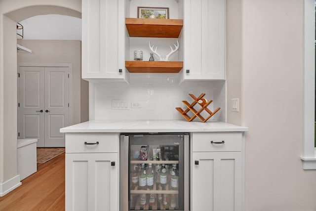 20111 N Woodland Cir, Mokena, IL 60448 - indoor dry bar with beverage cooler, light wood-type flooring, decorative backsplash, and arched walkways
