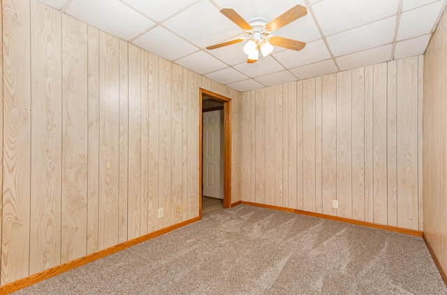 1220 Highland Ave, Lockport, IL 60441 - carpeted spare room featuring a drop ceiling, wood walls, a ceiling fan, and baseboards