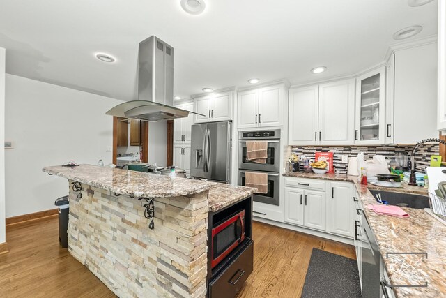 645 Saint Christopher Ct, Aurora, IL 60506 - kitchen with appliances with stainless steel finishes, island range hood, white cabinetry, light wood-type flooring, and recessed lighting
