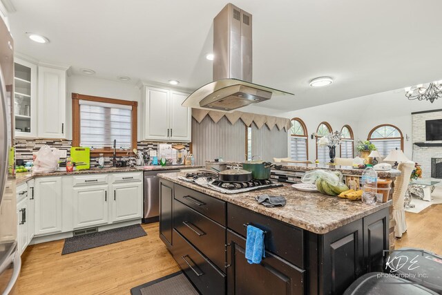 645 Saint Christopher Ct, Aurora, IL 60506 - kitchen with island exhaust hood, stainless steel appliances, white cabinetry, decorative backsplash, and light wood-style floors
