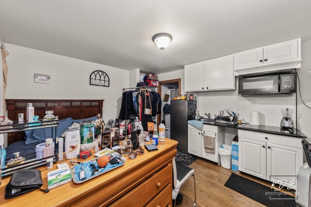 645 Saint Christopher Ct, Aurora, IL 60506 - kitchen with black microwave, freestanding refrigerator, white cabinetry, and light wood finished floors