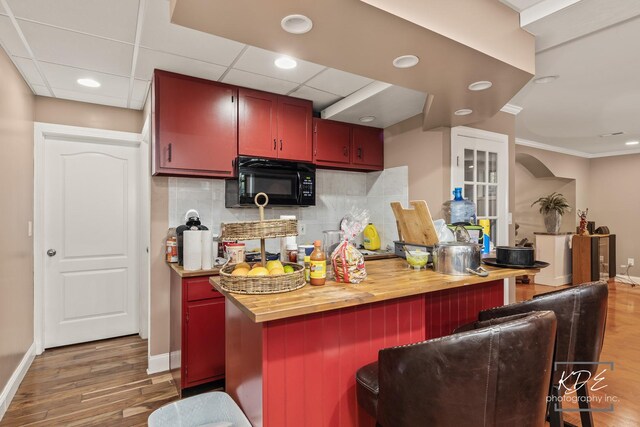 645 Saint Christopher Ct, Aurora, IL 60506 - kitchen with black microwave, wood finished floors, recessed lighting, backsplash, and butcher block counters