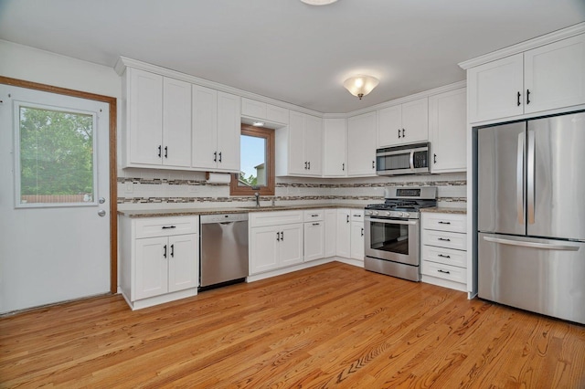 8932 Pebble Beach Ln, Orland Park, IL 60462 - kitchen featuring appliances with stainless steel finishes, white cabinets, tasteful backsplash, and light wood-type flooring