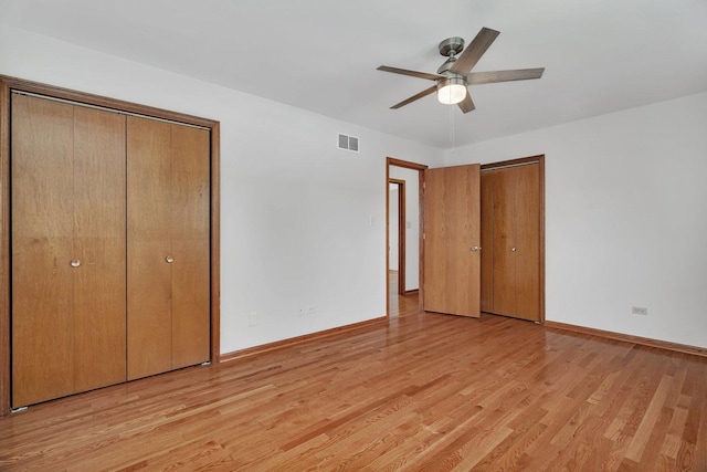 8932 Pebble Beach Ln, Orland Park, IL 60462 - unfurnished bedroom with light wood-type flooring, two closets, and ceiling fan