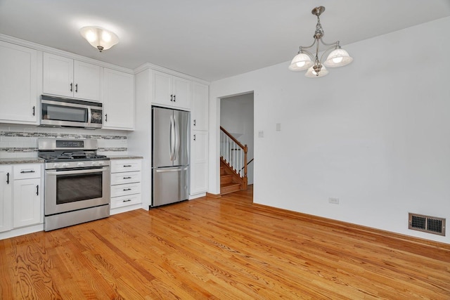 8932 Pebble Beach Ln, Orland Park, IL 60462 - kitchen with appliances with stainless steel finishes, decorative backsplash, white cabinets, and light wood-style flooring