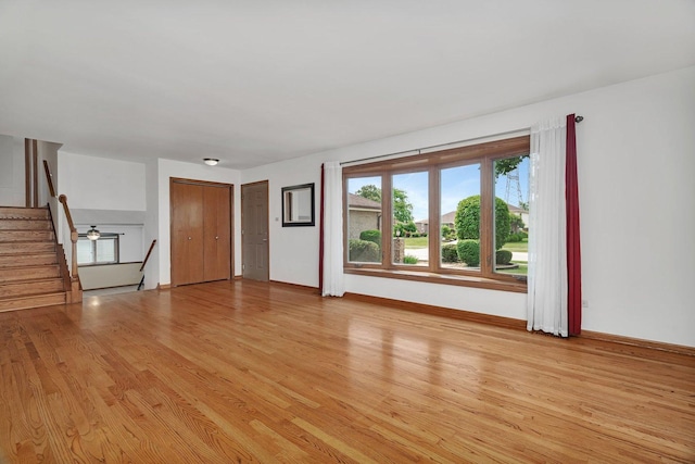 8932 Pebble Beach Ln, Orland Park, IL 60462 - unfurnished living room featuring light wood-style flooring and stairs