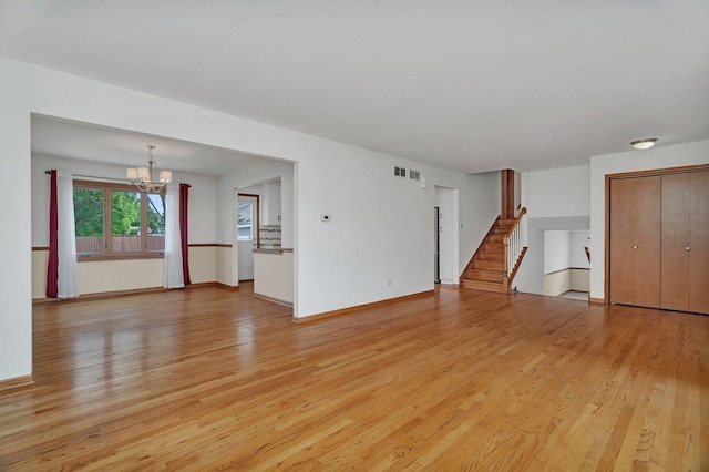 8932 Pebble Beach Ln, Orland Park, IL 60462 - unfurnished living room with a chandelier, light wood-type flooring, and stairway