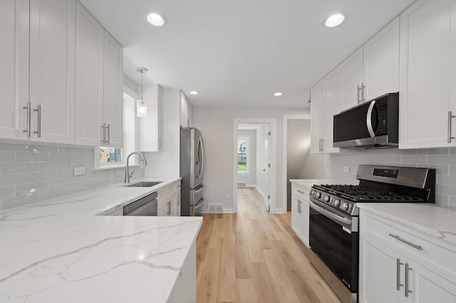7810 N Neva Ave, Niles, IL 60714 - kitchen with stainless steel appliances, white cabinetry, healthy amount of natural light, recessed lighting, and light stone countertops