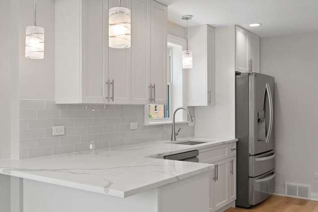 7810 N Neva Ave, Niles, IL 60714 - kitchen with stainless steel fridge, backsplash, light stone counters, white cabinetry, and pendant lighting