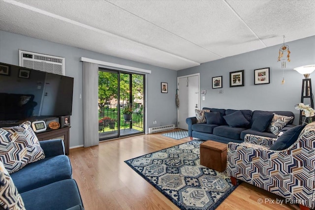 134 Klein Creek Ct Unit 4D, Carol Stream, IL 60188 - living room with a baseboard heating unit, a wall mounted air conditioner, a textured ceiling, and wood finished floors