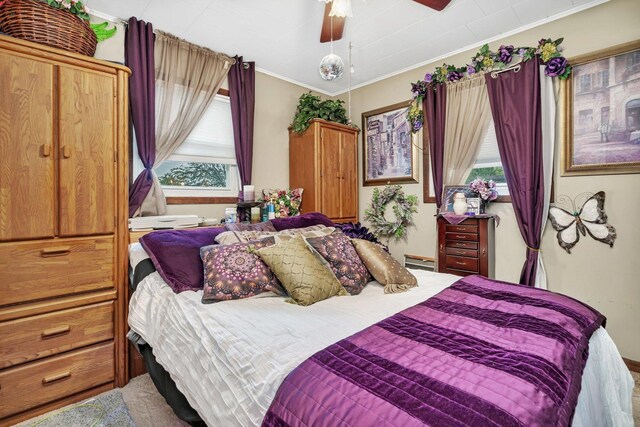 5203 W Court St, Monee, IL 60449 - carpeted bedroom featuring multiple windows, ornamental molding, baseboard heating, and a ceiling fan
