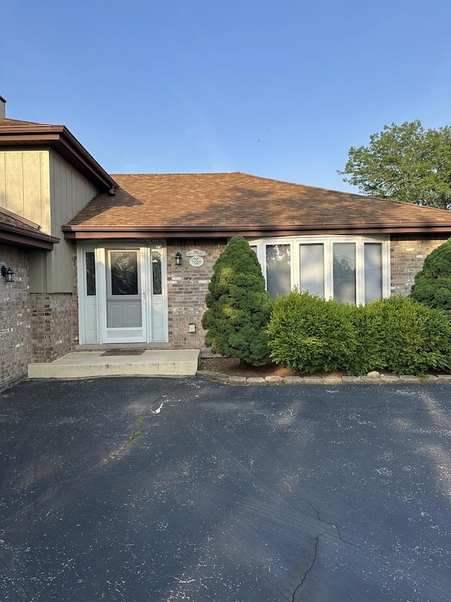 19205 Ada St, Lansing, IL 60438 - view of exterior entry with brick siding and roof with shingles