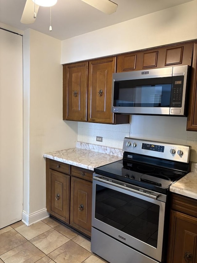 6007 N Sheridan Rd Unit 24H, Chicago, IL 60660 - kitchen featuring appliances with stainless steel finishes, tasteful backsplash, dark brown cabinetry, and light tile patterned floors