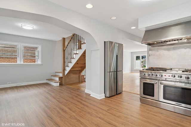 7032 W 63rd Pl, Chicago, IL 60638 - kitchen featuring stainless steel appliances, light wood-type flooring, arched walkways, recessed lighting, and wall chimney range hood