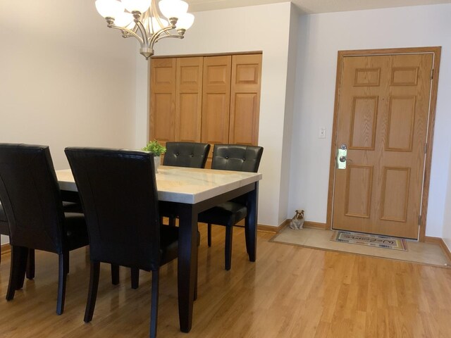 6560 W Diversey Ave Unit 417, Chicago, IL 60707 - dining room featuring a chandelier and light wood-type flooring