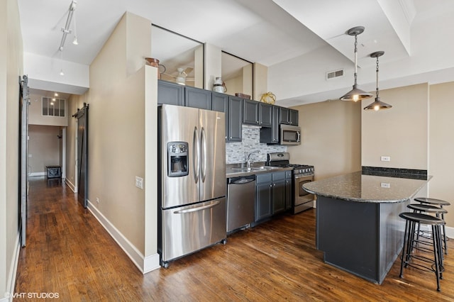 165 N Canal St Unit 1231, Chicago, IL 60606 - kitchen with stainless steel appliances, a barn door, dark wood-style floors, and a kitchen bar