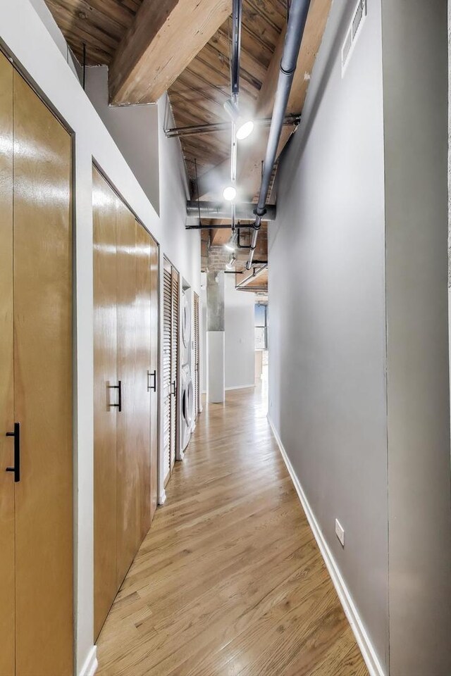 2310 S Canal St Unit 401, Chicago, IL 60616 - hallway featuring light wood finished floors, stacked washer / drying machine, and beam ceiling