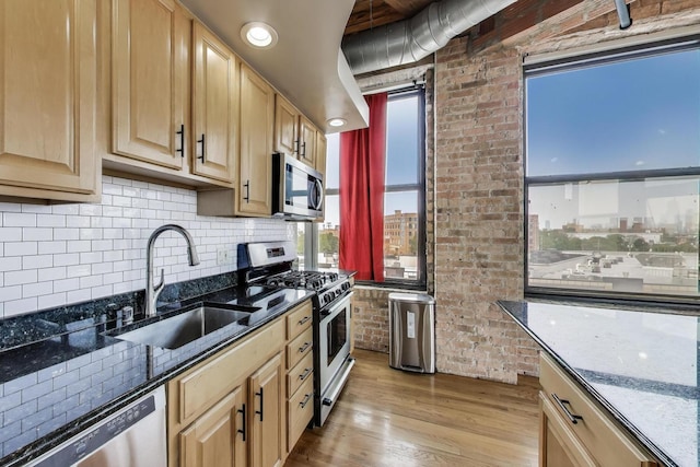 2310 S Canal St Unit 401, Chicago, IL 60616 - kitchen with appliances with stainless steel finishes, light wood-type flooring, dark stone countertops, light brown cabinetry, and brick wall