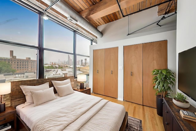 2310 S Canal St Unit 401, Chicago, IL 60616 - bedroom featuring multiple closets, light wood-style flooring, and a wooden ceiling with exposed beams