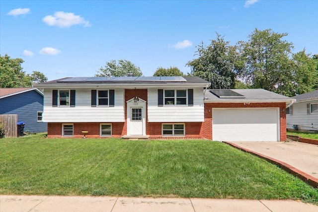 1209 Gettysburg Dr, Bloomington, IL 61704 - raised ranch featuring a front lawn, roof mounted solar panels, driveway, and a garage