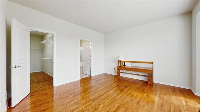 3201 Rockwell Cir, Mundelein, IL 60060 - unfurnished bedroom with light wood-style flooring, a walk in closet, a closet, and ensuite bath