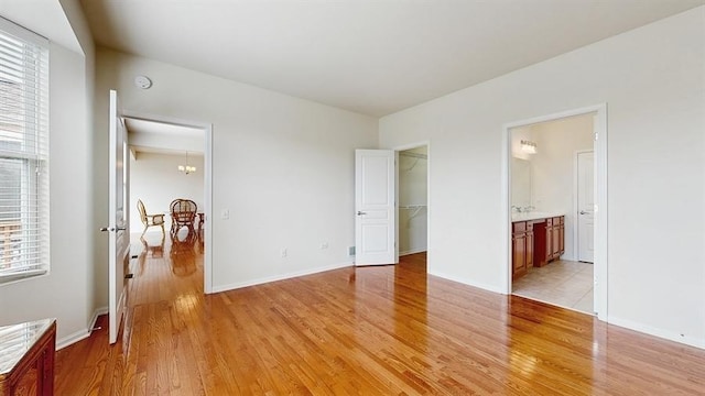3201 Rockwell Cir, Mundelein, IL 60060 - unfurnished bedroom featuring light wood finished floors, multiple windows, a spacious closet, and ensuite bath