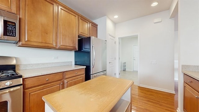 3201 Rockwell Cir, Mundelein, IL 60060 - kitchen featuring appliances with stainless steel finishes, light countertops, brown cabinets, light wood-type flooring, and recessed lighting
