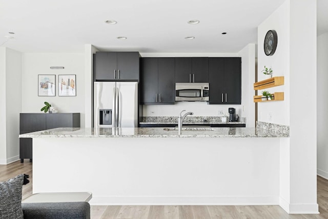 737 W Washington Blvd Unit 3308, Chicago, IL 60661 - kitchen featuring stainless steel appliances, dark cabinets, light wood-style flooring, and recessed lighting