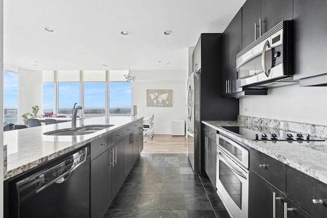 737 W Washington Blvd Unit 3308, Chicago, IL 60661 - kitchen featuring black appliances, dark cabinets, healthy amount of natural light, light stone countertops, and recessed lighting