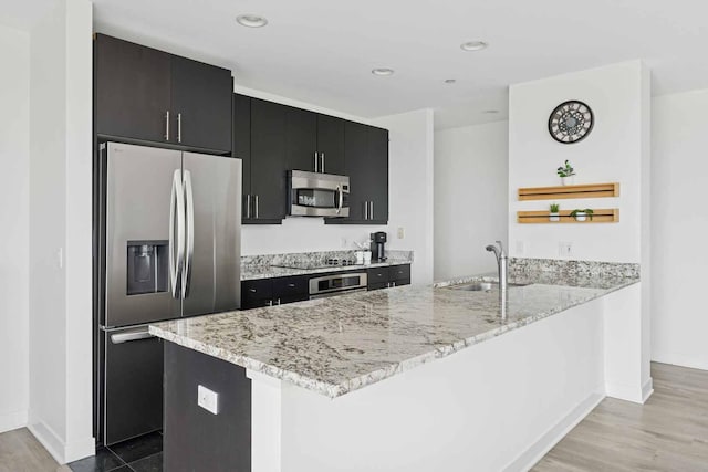 737 W Washington Blvd Unit 3308, Chicago, IL 60661 - kitchen with stainless steel appliances, dark cabinetry, open shelves, a peninsula, and light wood-type flooring