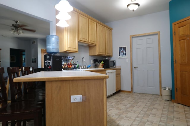 1053 Sycamore St, Beecher, IL 60401 - kitchen with white dishwasher, stainless steel microwave, a kitchen bar, light brown cabinetry, and a ceiling fan