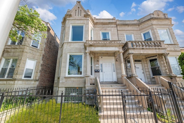 4251 W Jackson Blvd, Chicago, IL 60624 - multi unit property featuring a fenced front yard, stone siding, and a gate