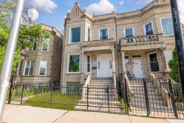 4251 W Jackson Blvd, Chicago, IL 60624 - view of front facade with stone siding, a gate, and a fenced front yard