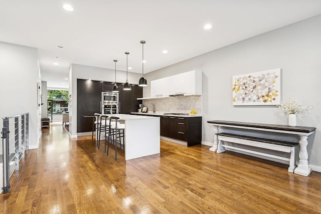 874 N Marshfield Ave Unit 1, Chicago, IL 60622 - kitchen with modern cabinets, a kitchen island, stainless steel appliances, a kitchen breakfast bar, and decorative backsplash