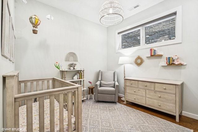874 N Marshfield Ave Unit 1, Chicago, IL 60622 - bedroom featuring a nursery area, a chandelier, and wood finished floors
