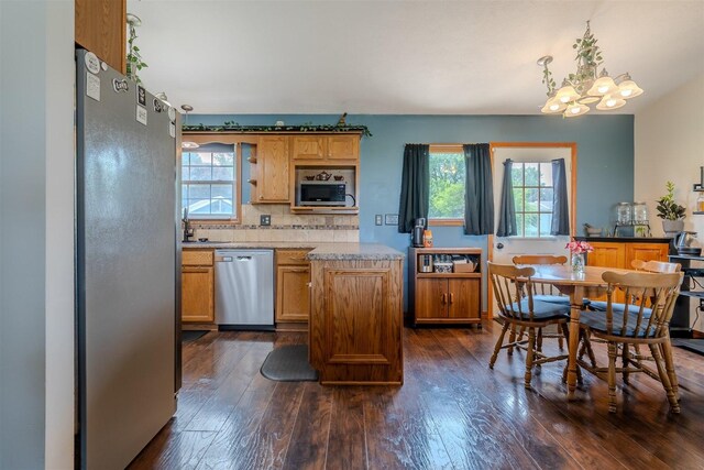 107 W 10th St, Gridley, IL 61744 - kitchen featuring appliances with stainless steel finishes, a chandelier, dark wood-style floors, and decorative backsplash