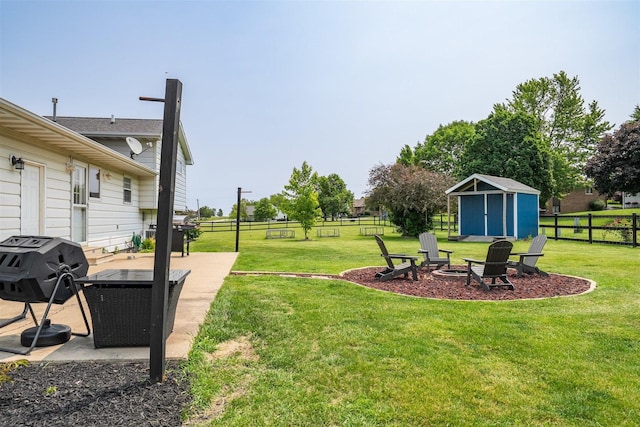 107 W 10th St, Gridley, IL 61744 - fenced backyard with a storage shed, a fire pit, and a patio area