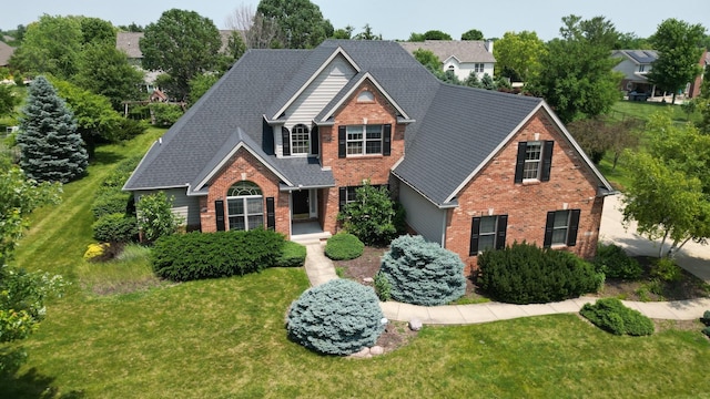 1904 Mullikin Dr, Champaign, IL 61822 - traditional home featuring brick siding, a front lawn, and a shingled roof