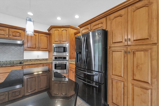 1904 Mullikin Dr, Champaign, IL 61822 - kitchen featuring stainless steel appliances, under cabinet range hood, brown cabinets, hanging light fixtures, and decorative backsplash