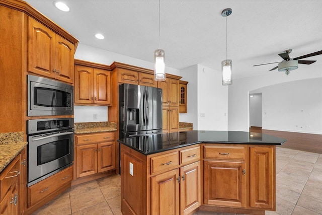 1904 Mullikin Dr, Champaign, IL 61822 - kitchen featuring stainless steel appliances, brown cabinets, a center island, decorative light fixtures, and a ceiling fan