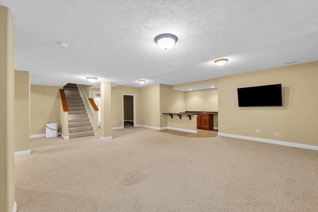 1904 Mullikin Dr, Champaign, IL 61822 - finished below grade area with light colored carpet, stairway, a textured ceiling, and bar