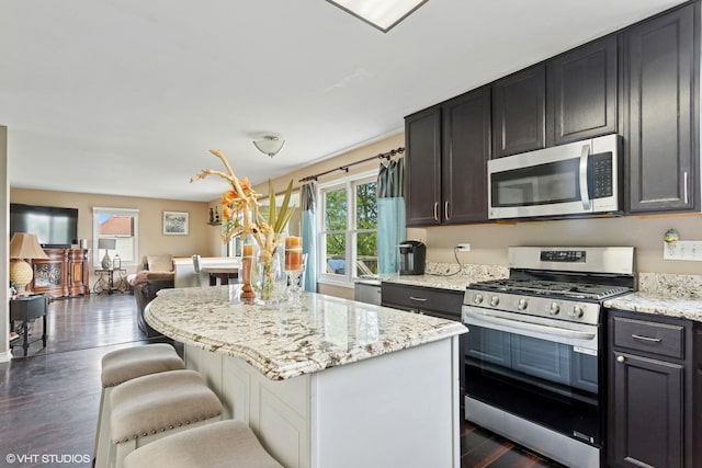2855 Weld Rd, Elgin, IL 60124 - kitchen with appliances with stainless steel finishes, dark wood-type flooring, a center island, open floor plan, and light stone countertops