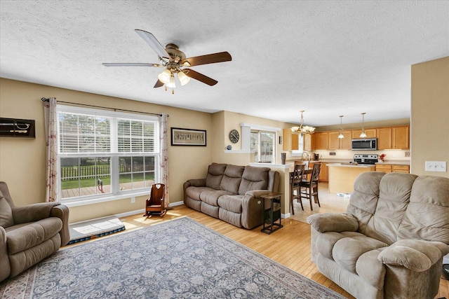 3911 Tallgrass Dr, Champaign, IL 61822 - living area featuring light wood-style floors, a chandelier, ceiling fan, and a textured ceiling