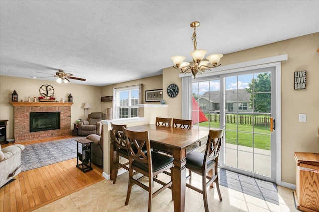3911 Tallgrass Dr, Champaign, IL 61822 - dining area featuring a chandelier, ceiling fan, a fireplace, and a textured ceiling