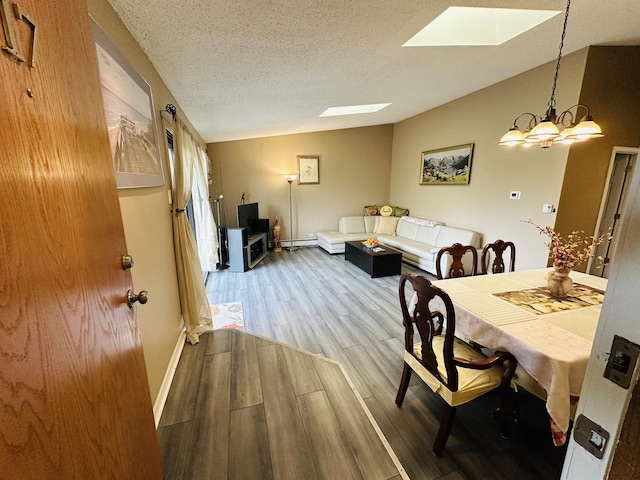 11 Echo Ct Unit 17, Vernon Hills, IL 60061 - dining room featuring a skylight, wood finished floors, a textured ceiling, a chandelier, and vaulted ceiling