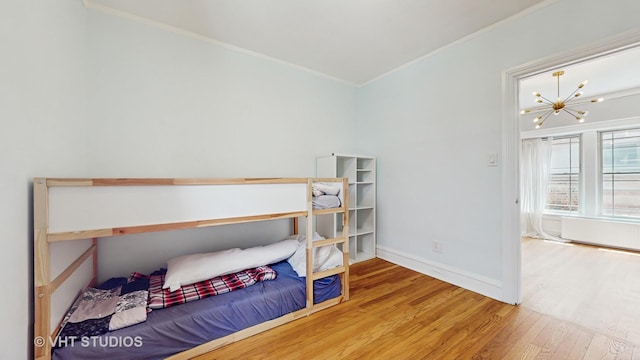 117 S Grove Ave, Oak Park, IL 60302 - bedroom with wood finished floors, ornamental molding, and a chandelier