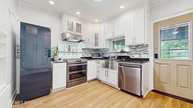 117 S Grove Ave, Oak Park, IL 60302 - kitchen with stainless steel appliances, under cabinet range hood, dark countertops, white cabinets, and ornamental molding