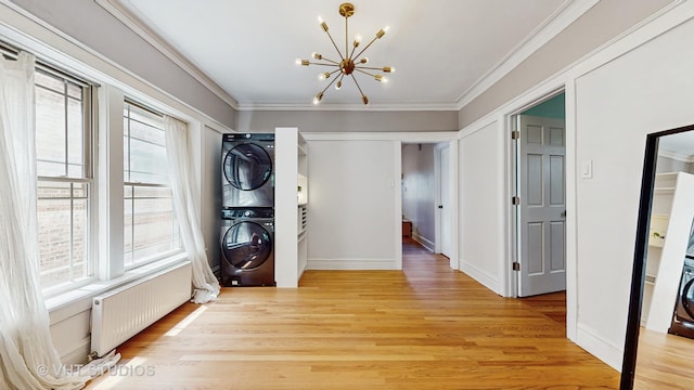 117 S Grove Ave, Oak Park, IL 60302 - washroom featuring stacked washer / dryer, radiator heating unit, a chandelier, crown molding, and light wood-style flooring